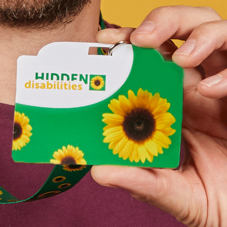A person holding up a Sunflower card on a Sunflower lanyard